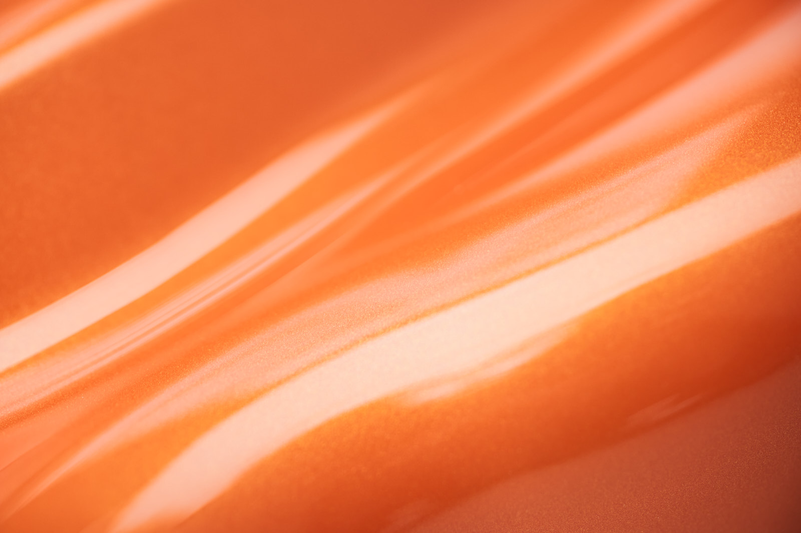 Detailaufnahme der Lichtreklektion in einer orange lackierten Oberfläche